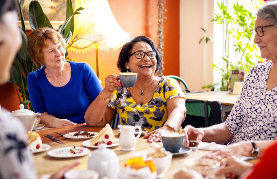 people sitting around a table enjoying tea and cake